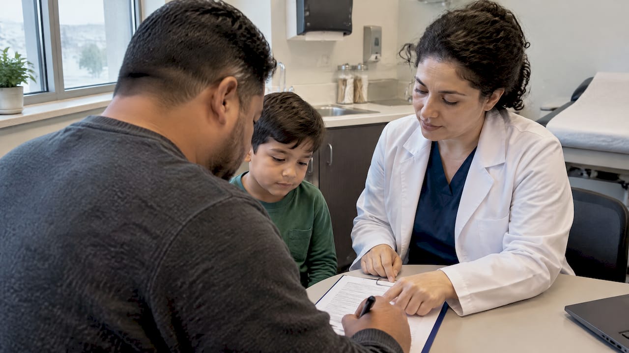 Parent signing vaccine consent with child present